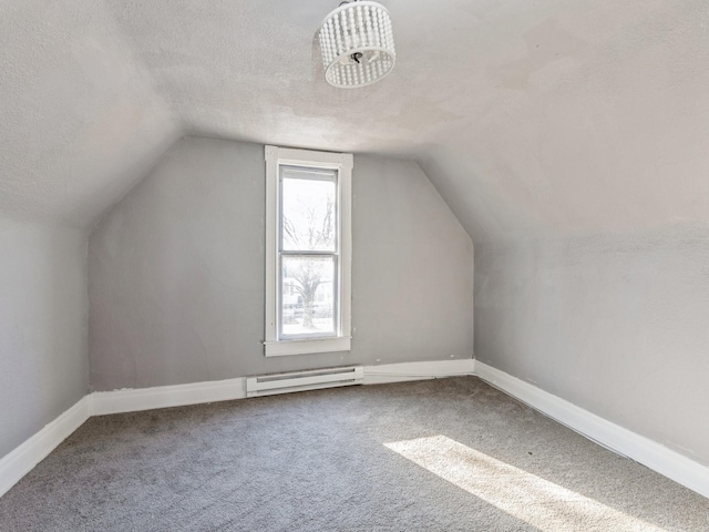 additional living space with baseboard heating, lofted ceiling, carpet floors, and a textured ceiling