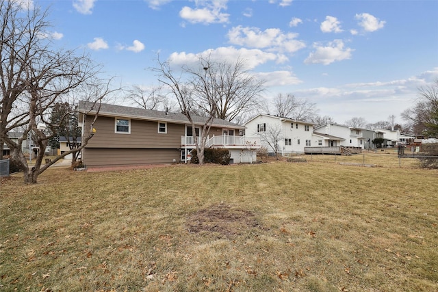 back of property featuring a yard, fence, and a wooden deck