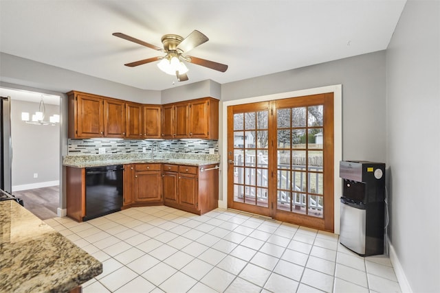 kitchen with stainless steel refrigerator, black dishwasher, tasteful backsplash, light stone countertops, and ceiling fan with notable chandelier