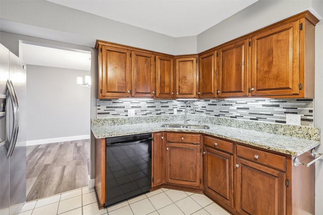 kitchen with sink, light stone countertops, black dishwasher, and stainless steel refrigerator with ice dispenser