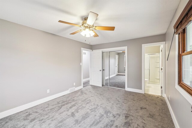 unfurnished bedroom with ceiling fan, connected bathroom, carpet floors, and a closet