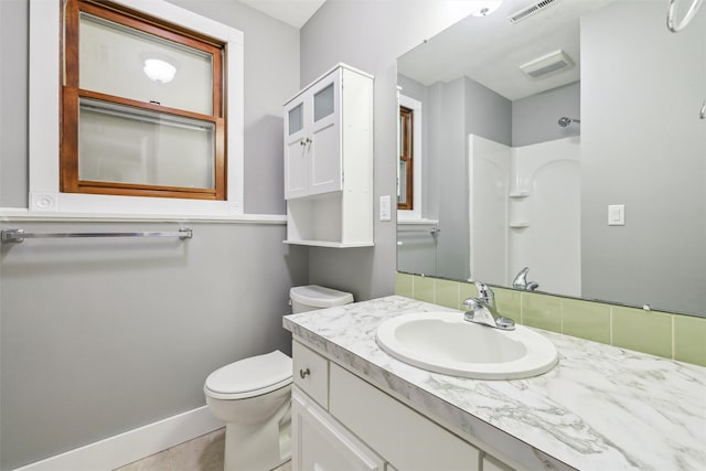 bathroom featuring vanity, tile patterned floors, toilet, and walk in shower