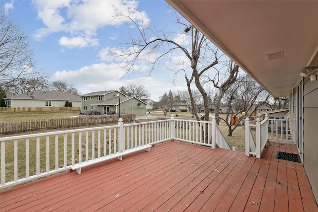 deck with a yard, fence, and a residential view