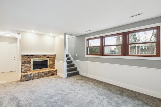 unfurnished living room featuring carpet flooring and a fireplace