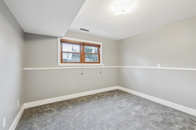 carpeted empty room with visible vents, a textured ceiling, and baseboards