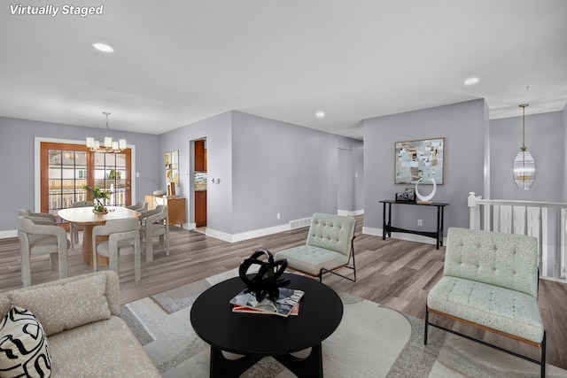 living area with a chandelier, wood finished floors, visible vents, and recessed lighting