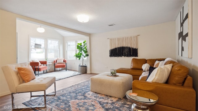 living room featuring wood-type flooring and vaulted ceiling