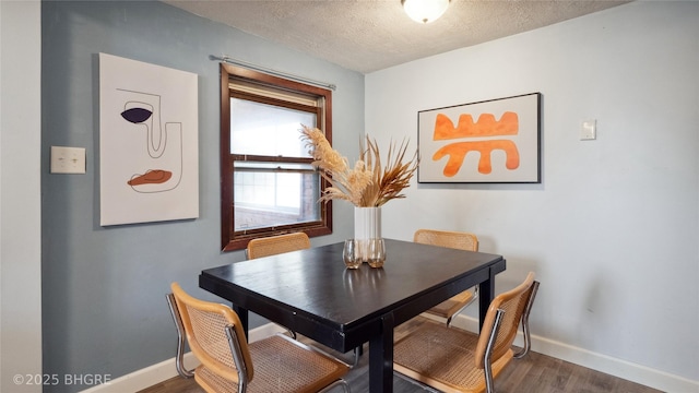 dining room featuring dark hardwood / wood-style flooring and a textured ceiling