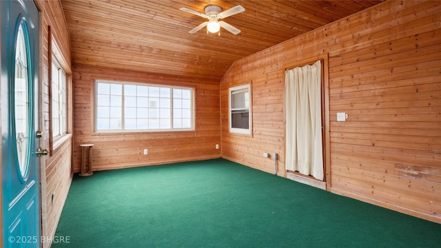 carpeted spare room featuring ceiling fan, lofted ceiling, wooden walls, and wooden ceiling