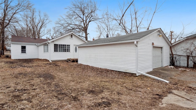 rear view of property with a garage and an outdoor structure