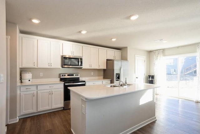 kitchen featuring stainless steel appliances, sink, a center island with sink, and white cabinets