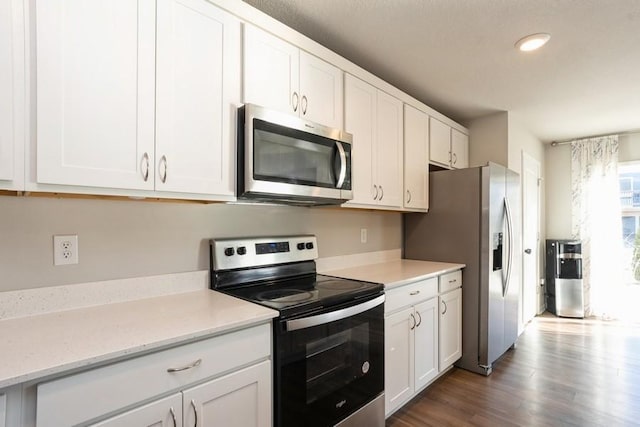 kitchen with white cabinetry, appliances with stainless steel finishes, and dark wood-type flooring