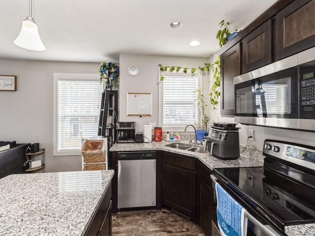 kitchen with sink, a wealth of natural light, dark brown cabinets, and stainless steel appliances