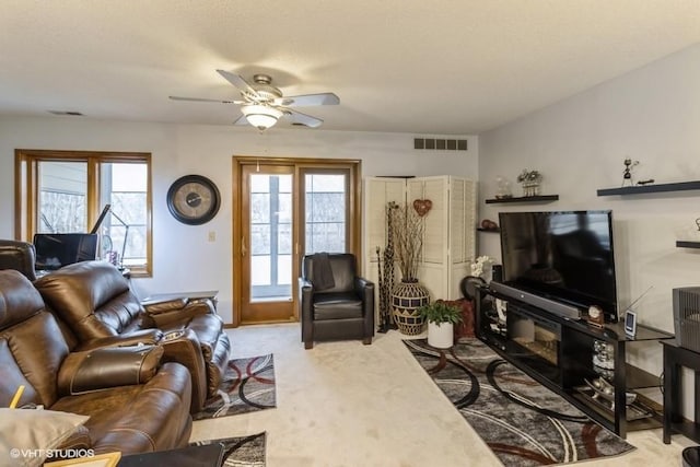 living room with light carpet, a wealth of natural light, and ceiling fan