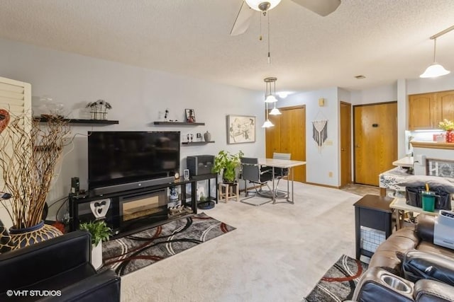 living room featuring ceiling fan, light colored carpet, and a textured ceiling