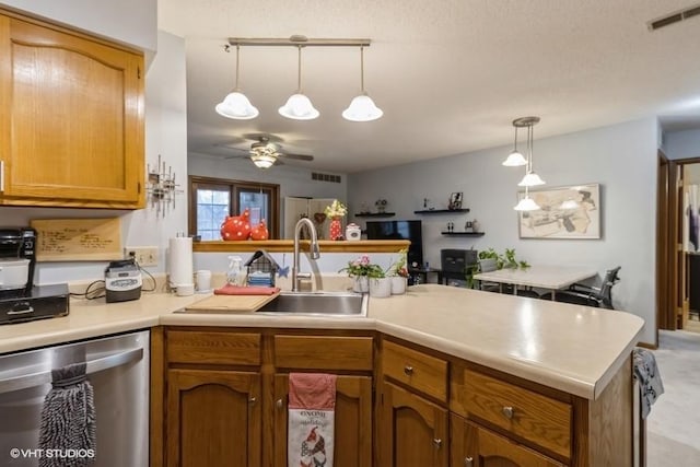 kitchen featuring ceiling fan, stainless steel dishwasher, sink, and hanging light fixtures