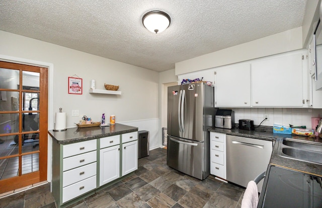 kitchen featuring sink, tasteful backsplash, a textured ceiling, appliances with stainless steel finishes, and white cabinets