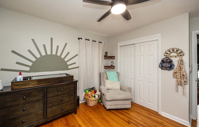 living area featuring hardwood / wood-style flooring and ceiling fan