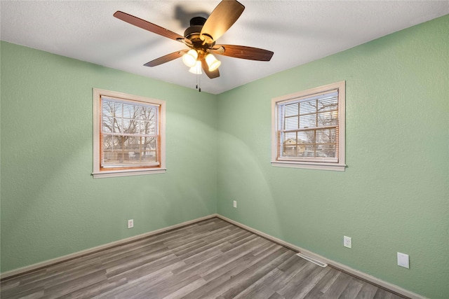 empty room featuring hardwood / wood-style floors, a textured ceiling, and ceiling fan