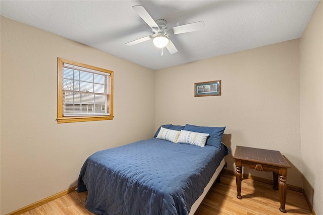 bedroom with a textured ceiling, light hardwood / wood-style flooring, and ceiling fan