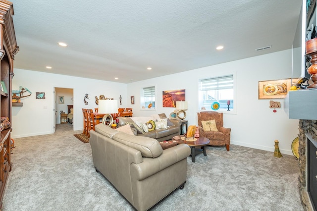 living room featuring light colored carpet, a textured ceiling, and a fireplace