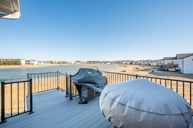 deck featuring a water view and a grill