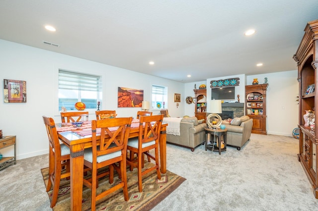 carpeted dining room featuring a fireplace