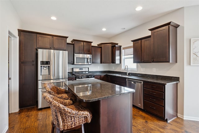 kitchen with dark wood-type flooring, appliances with stainless steel finishes, a center island, and sink