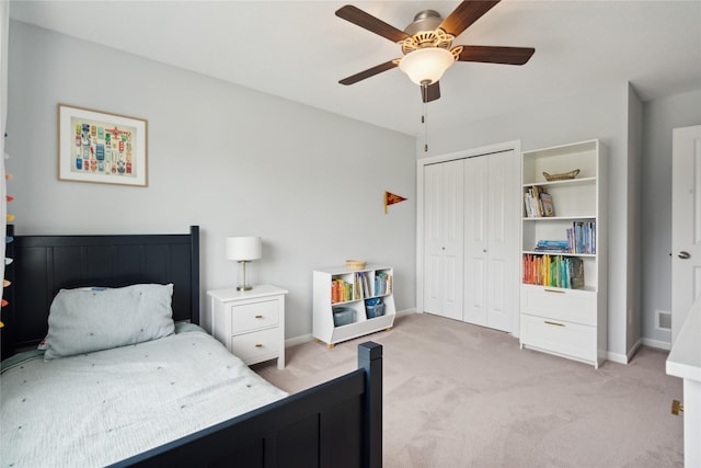 carpeted bedroom with ceiling fan and a closet