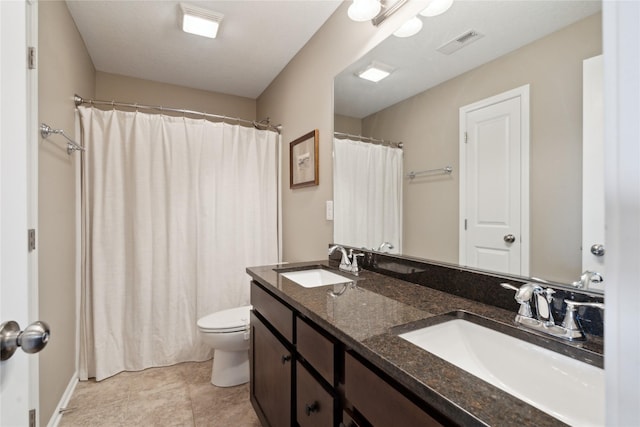 bathroom featuring vanity, tile patterned floors, and toilet