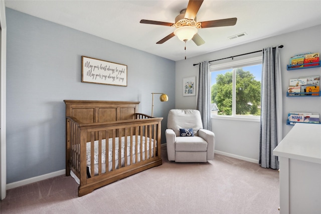 carpeted bedroom with a nursery area and ceiling fan