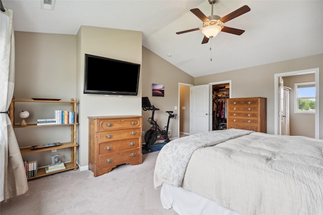 bedroom featuring lofted ceiling, a walk in closet, light carpet, a closet, and ceiling fan