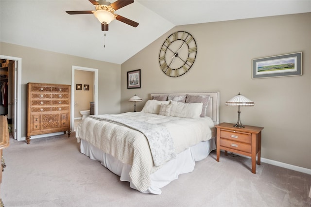 carpeted bedroom featuring ceiling fan, connected bathroom, a spacious closet, vaulted ceiling, and a closet