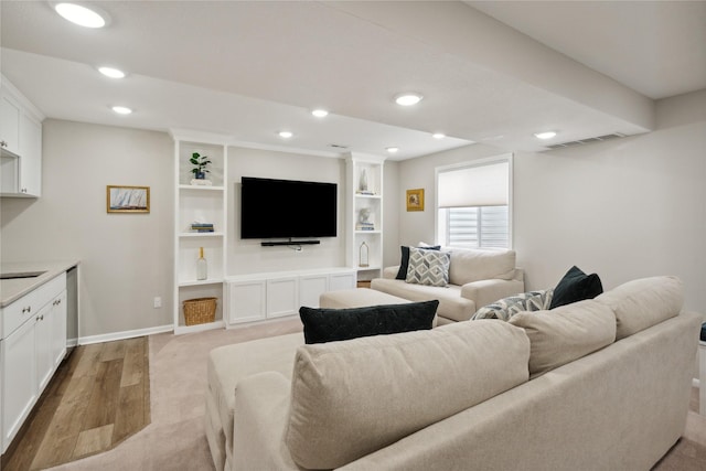 living room with light wood-type flooring and built in shelves