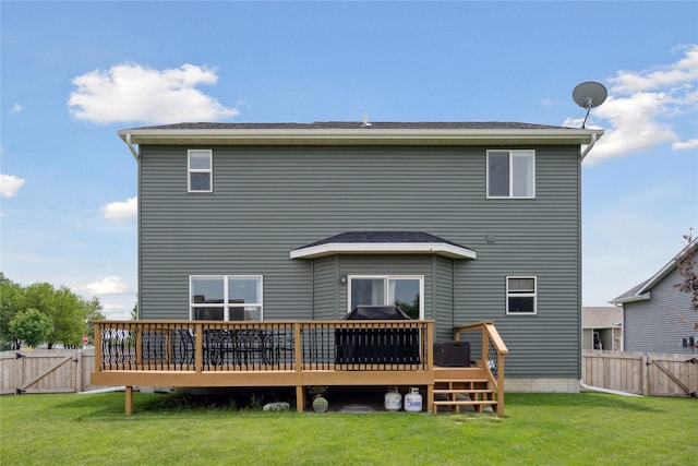 rear view of property with a wooden deck and a yard