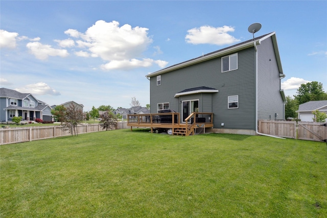 rear view of house with a wooden deck and a yard