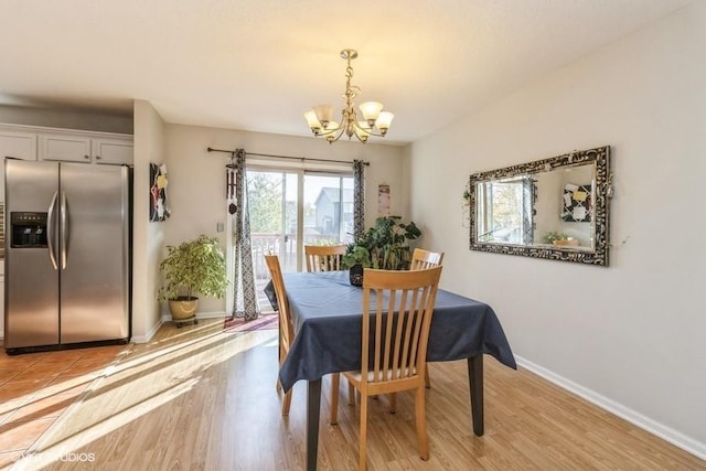 dining space featuring light hardwood / wood-style floors and a chandelier