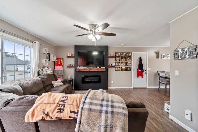 living room featuring ceiling fan, a fireplace, and dark hardwood / wood-style floors