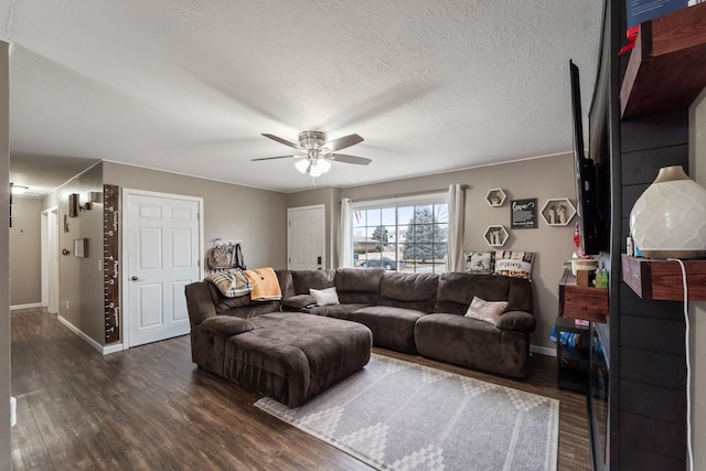 living room with ceiling fan, dark hardwood / wood-style flooring, and a textured ceiling