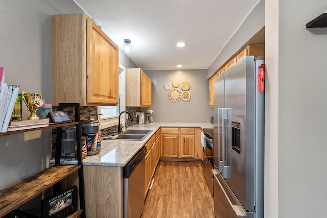 kitchen featuring sink, light hardwood / wood-style flooring, stainless steel appliances, light brown cabinetry, and decorative backsplash