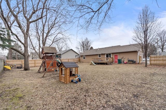 back of house featuring a wooden deck and a playground