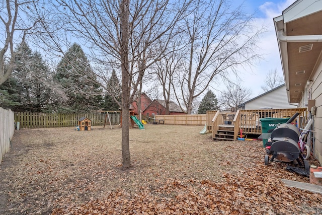 view of yard featuring a playground and a wooden deck