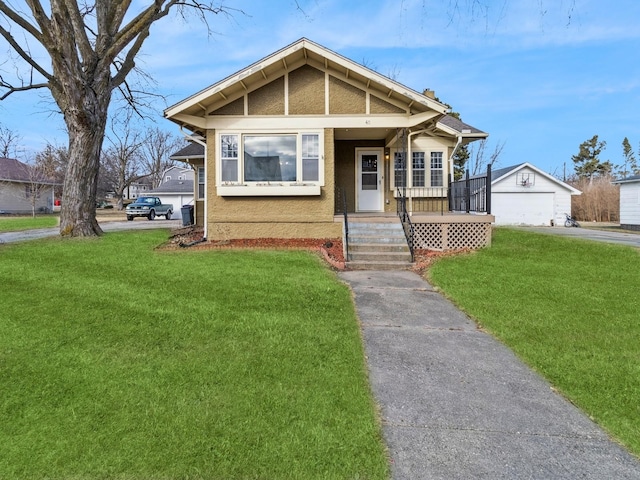 bungalow featuring a garage, an outdoor structure, covered porch, and a front lawn