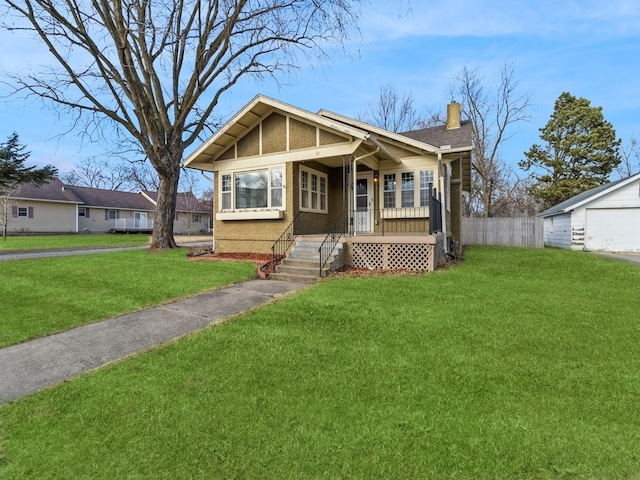 view of front of property featuring a garage, a front lawn, and a porch