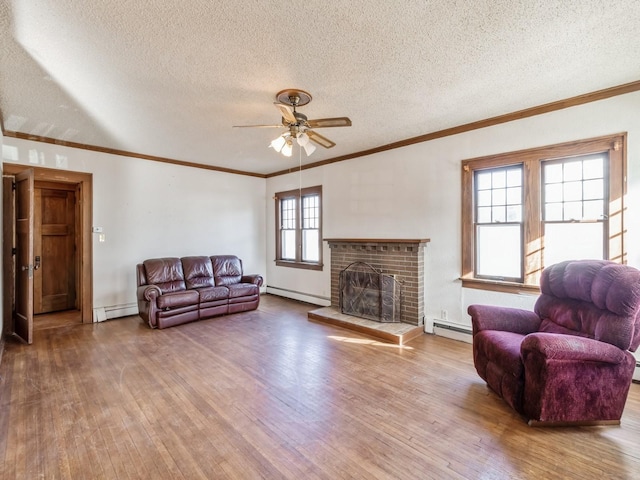 living room featuring baseboard heating, a brick fireplace, and hardwood / wood-style flooring