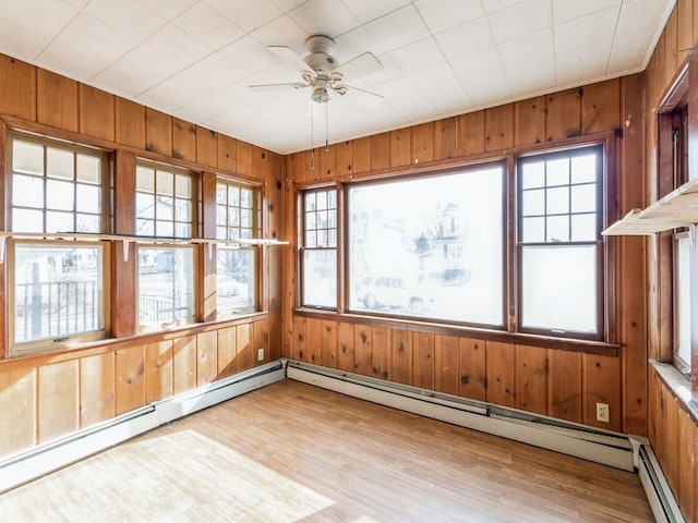 unfurnished sunroom featuring ceiling fan and a baseboard radiator