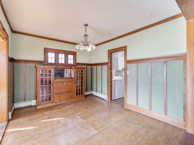 empty room with crown molding, a chandelier, a textured ceiling, a baseboard radiator, and light hardwood / wood-style floors