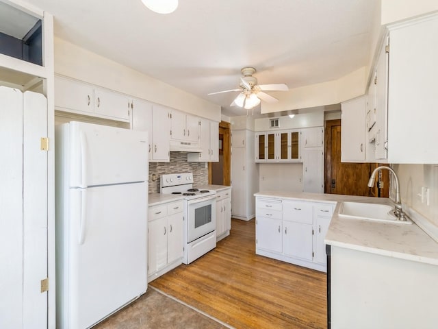 kitchen with sink, white appliances, decorative backsplash, and white cabinets