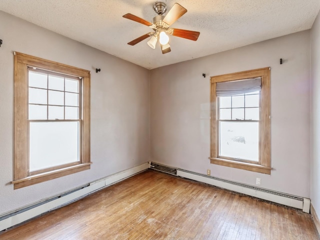 spare room with ceiling fan, a baseboard radiator, light hardwood / wood-style flooring, and a textured ceiling