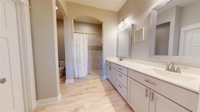 bathroom featuring a shower with curtain, vanity, and toilet